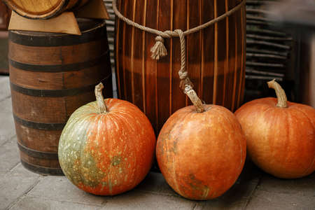 Pumpkins on sidewalk in city street, festive holiday decoration of storefronts and buildings. Halloween decoration outdoor. Space for text. Happy halloween. Autumn market in townの写真素材