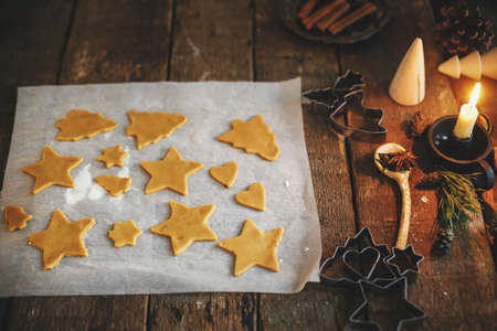 Making traditional christmas gingerbread cookies on rustic table. Gingerbread raw cookies in...