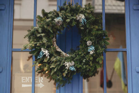 Stylish modern christmas wreath with herbs on old blue doors. Christmas festive  decor for winter holidays in european city street. Merry Christmas!の写真素材