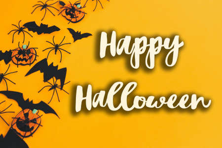 Happy Halloween text sign on pumpkins, jack o lanterns, spiders, bats border on orange background....