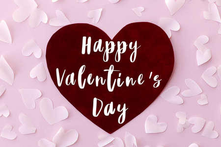 Happy Valentines Day greeting card. Happy Valentine's Day text on stylish red heart on pink...