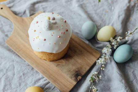 Homemade easter bread, natural dyed eggs and spring blossom on rustic table in room. Happy Easter!...