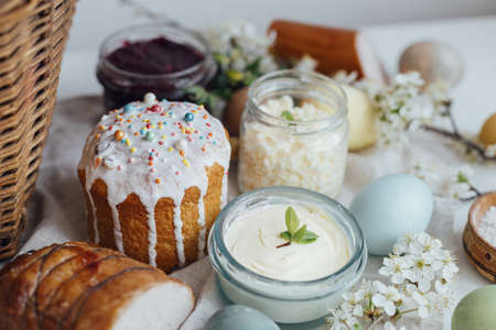 Happy Easter! Stylish easter bread and natural dyed eggs on rustic table with spring blossom and...