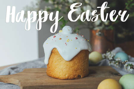 Happy Easter greeting card. Happy Easter text and stylish easter bread, natural dyed eggs and spring blossom on rustic table. Seasons greeting card, handwritten letteringの写真素材