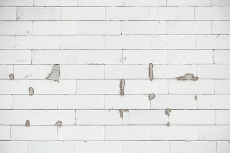Aerated concrete blocks wall. Autoclaved aerated concrete blocks  masonry close up with adhesive. Process of house building at construction site. Aerated concrete blocks wallpaper patternの写真素材