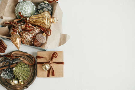 Merry Christmas! Stylish christmas vintage ornaments, gift, ribbon on rustic white table. Flat lay, space for text. Preparation for winter holidays, atmospheric time. Moody aesthetic bannerの写真素材