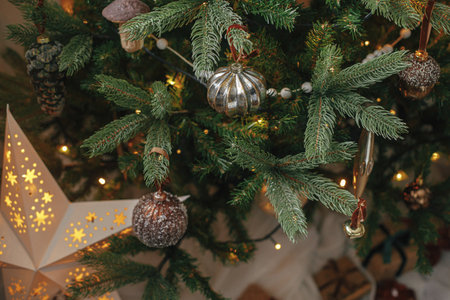 Christmas tree with vintage baubles and golden lights close up. Modern decorated christmas tree...