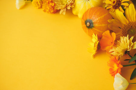 Colorful autumn flowers, pumpkins, pattypan squashes flat lay on yellow background. Happy Thanksgiving! Seasons greeting card template with space for text. Hello Fallの写真素材