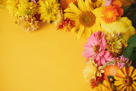 Happy Thanksgiving! Stylish autumn composition on yellow background. Colorful autumn flowers, pumpkins, pattypan squashes flat lay. Seasons greeting card template with space for text. Hello Fallの写真素材