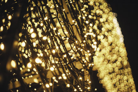 Stylish christmas golden lights in town square in evening, festive illumination bokeh. Modern...