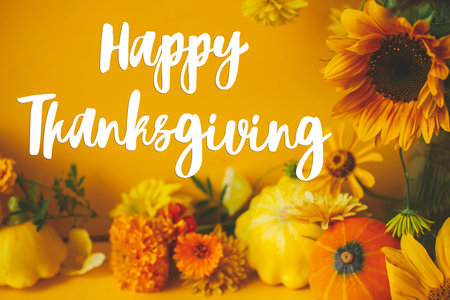 Happy Thanksgiving greeting card. Happy Thanksgiving text and colorful flowers, pumpkin, squashes modern composition on yellow background. Handwritten letteringの写真素材