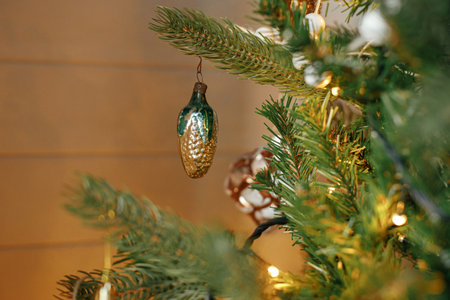 Christmas tree with vintage baubles and golden lights. Modern decorated christmas tree branches with...
