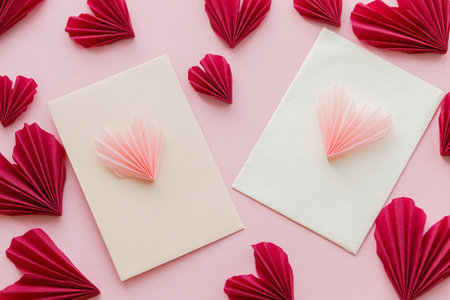 Happy Valentine's day! Stylish envelopes with pink and red hearts flat lay on pink paper background....