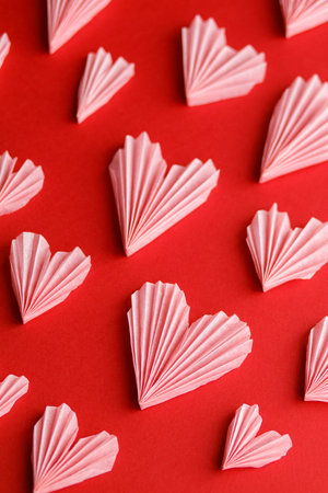 Happy Valentine's day! Stylish pink hearts on red paper background flat lay. Modern cute valentine...