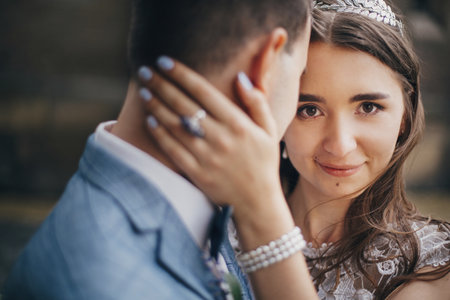 Portraits of beautiful sensual wedding couple gently hugging in european city. Stylish bride and groom kissing and embracing on background of old church. Romantic moment. Provence weddingの写真素材