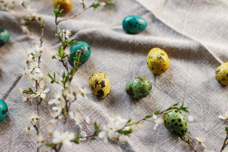 Stylish easter eggs and blooming cherry flowers on rustic table. Happy Easter! Rustic easter still...