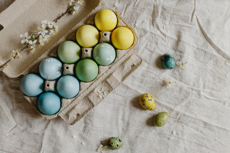 Rustic easter flat lay. Stylish easter eggs and blooming cherry branch on rustic table. Happy...