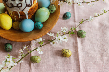 Happy Easter! Homemade easter bread and natural dyed easter eggs with spring flowers on wooden plate...