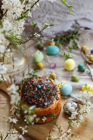 Happy Easter! Homemade easter bread and natural dyed easter eggs with spring flowers on linen napkin...