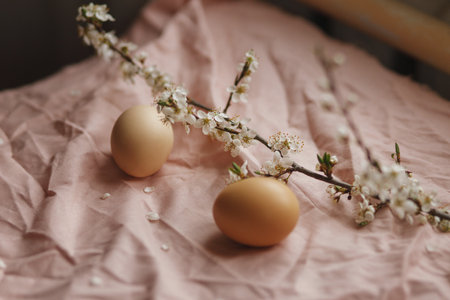 Natural eggs and blooming cherry branch on pink fabric background. Happy Easter! Rustic easter still life. Space for textの写真素材