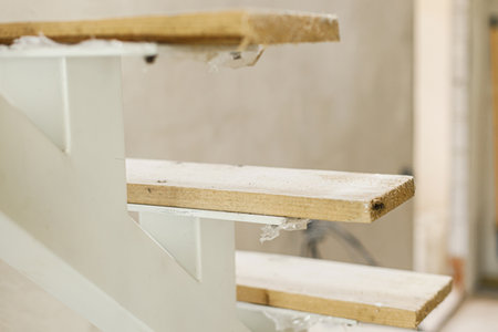 Unfinished wooden stairs to second floor in new building. Construction of house and home renovation conceptの写真素材