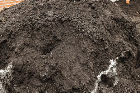 Black soil pile. Landscaping backyard and garden work concept. Clean soil for cultivation and gardening. Fertile groundの写真素材