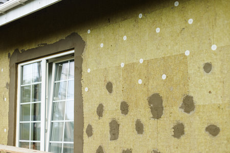Facade insulation with mineral wool, thermal improvement and energy saving. Modern farmhouse...