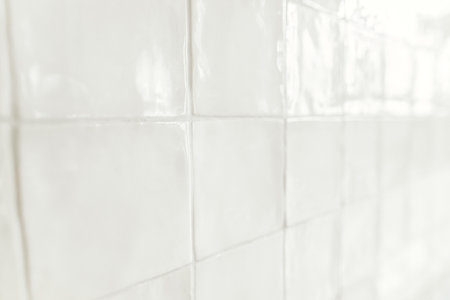 Modern tiles background. Installed white square rustic tiles wall close up in new scandinavian house. Stylish minimal kitchen design. Tile patternの写真素材