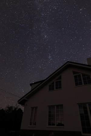 Amazing night sky with stars over modern farmhouse. Beautiful starry sky. Milky way galaxyの写真素材
