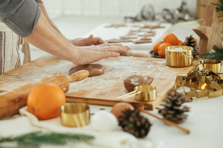 Man making christmas gingerbread cookies in modern white kitchen close up. Hands kneading...