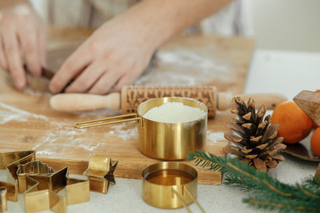 Man making christmas gingerbread cookies close up in modern white kitchen. Hands cutting gingerbread...