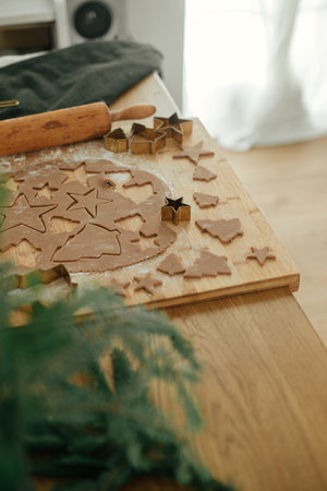 Gingerbread dough with golden cutters, rolling pin, cooking spices and festive decorations on rustic...