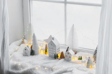 Atmospheric miniature winter village. Stylish cute little ceramic houses and christmas wooden trees...