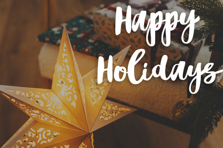 Happy Holidays text on stylish golden christmas star and christmas gifts. Merry Christmas. Season's greeting card. Handwritten signの写真素材
