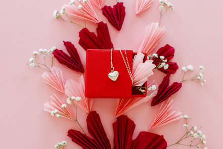 Happy Valentine's day ! Stylish pink and red hearts, flowers and heart necklace flat lay on pink background. Valentines hearts paper cutouts and jewelry gift. Love and mother's dayの写真素材