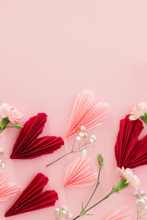 Valentines day flat lay. Stylish pink and red hearts composition with flowers on pink background, space for text. Happy Valentines day! Modern hearts paper cutouts. Love and mothers dayの写真素材