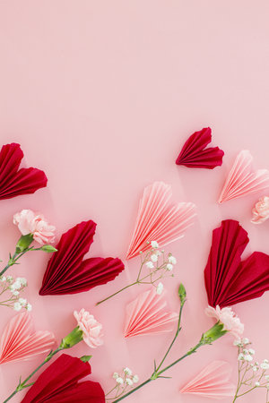 Happy Valentine's day ! Stylish pink and red hearts with flowers flat lay on pink background with space for text. Valentines hearts paper cutouts. Love and mothers day conceptの写真素材