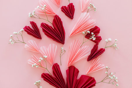 Happy Valentine's day ! Stylish pink and red hearts with gentle flowers flat lay on pink background. Valentines hearts paper cutouts. Love and mothers day conceptの写真素材