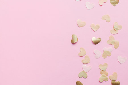 Stylish hearts on pink background flat lay. Happy Valentines day and happy mother's day. Valentine banner, gold hearts border with space for text. Mothers day cardの写真素材