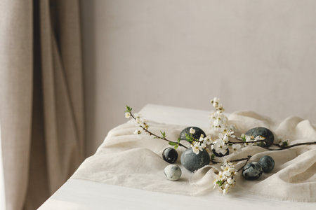 Happy Easter! Stylish easter eggs and spring flowers on linen cloth on rustic white table. Easter modern simple banner, space for text. Natural painted marble eggs. Seasons greetingsの写真素材