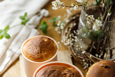 Baked fresh easter traditional bread on rustic wooden table with flowers. Making homemade easter cake. Orthodox traditional food paskaの写真素材