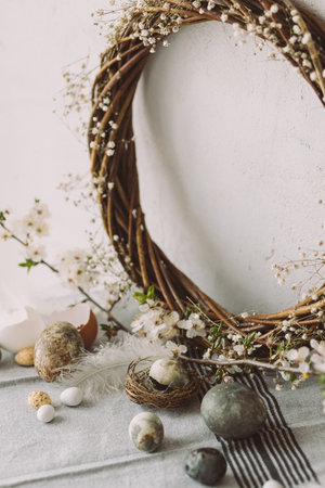 Stylish easter eggs, bunnies and cherry blossom composition on rustic table. Happy Easter! Modern...
