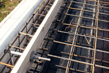 Reinforcement rods at construction site. Steel rebar mesh close up. Rusty steel reinforcement bars for concrete foundation or ceiling. Process of house buildingの写真素材