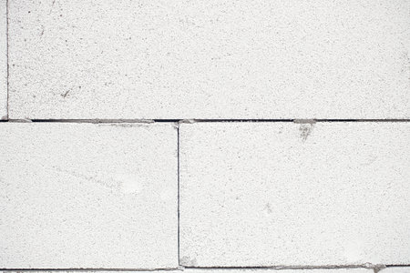 Aerated concrete blocks wall. Autoclaved aerated concrete blocks  masonry close up with adhesive. Process of house building at construction site. Aerated concrete blocks wallpaper patternの写真素材