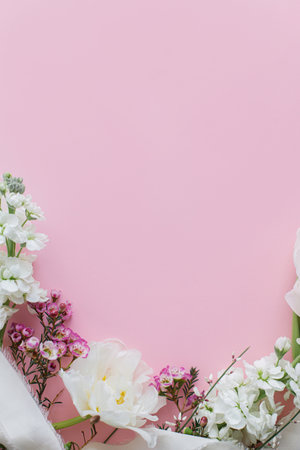 Stylish flowers flat lay on pink background with space for text. Happy womens day and Mothers day. Beautiful tulips and spring flowers border, greeting card template. Floral bannerの写真素材