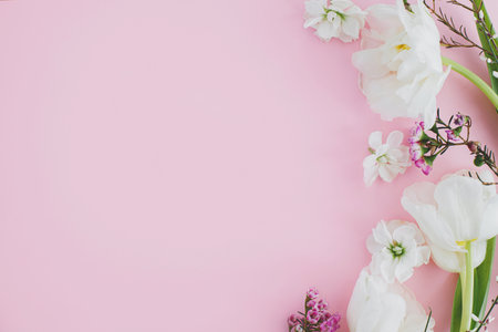 Happy Mothers day and Womens day. Stylish white flowers flat lay on pink background, space for text. Beautiful tender tulips and spring flowers border, greeting card template. Floral bannerの写真素材