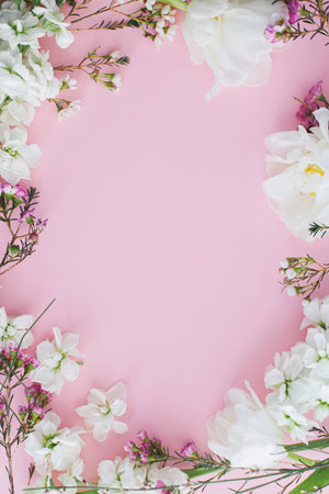 Stylish flowers flat lay on pink background with space for text. Happy womens day and Mothers day. Beautiful tulips and spring flowers frame, greeting card template. Floral bannerの写真素材
