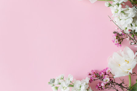 Stylish flowers flat lay on pink background with space for text. Happy womens day and Mothers day. Beautiful tulips and spring flowers border, greeting card template. Floral bannerの写真素材