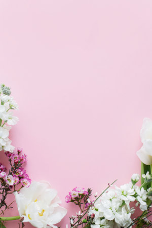 Happy Mothers day and Womens day. Stylish white flowers flat lay on pink background, space for text. Beautiful tender tulips and spring flowers border, greeting card template. Floral bannerの写真素材