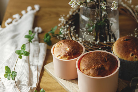Baked fresh easter traditional bread on rustic wooden table with flowers. Making homemade easter cake. Orthodox traditional food paskaの写真素材